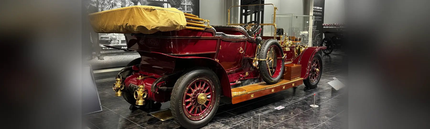 A deep-red 1910 Rolls-Royce Silver Ghost with brass lamps and wire wheels