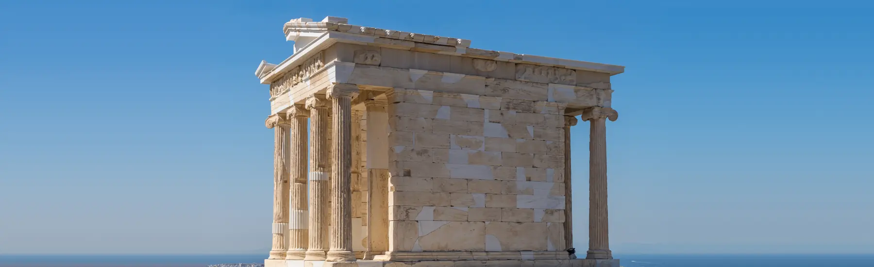The Temple of Athena Nike on the Acropolis: four Ionic columns against a clear blue sky